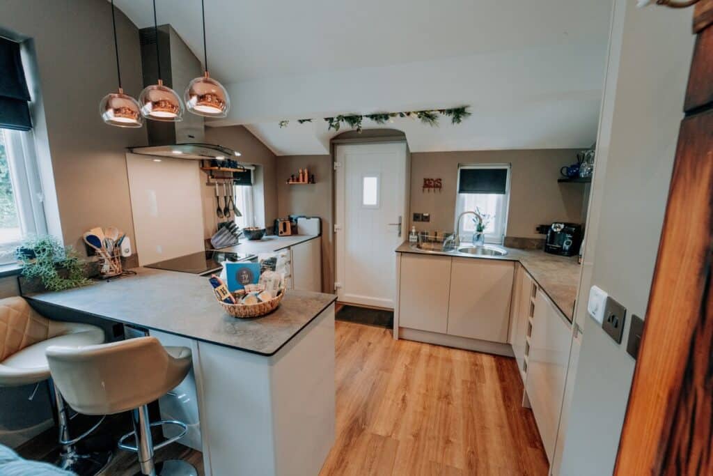 Tŷ Cosy kitchen with island and copper pendant lights