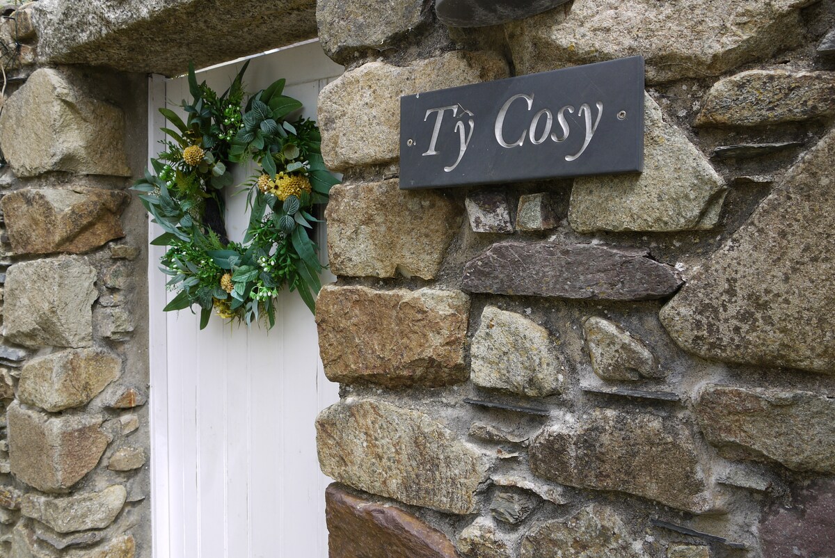Slate Tŷ Cosy name sign and wreath on the stone wall by the cottage door