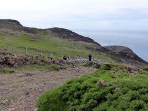 Walkers on the Pembrokeshire Coast Path above the sea, looking west